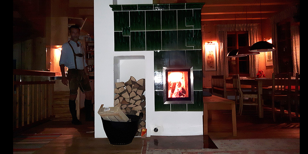 Kachelofen grün geflammt bei Nacht